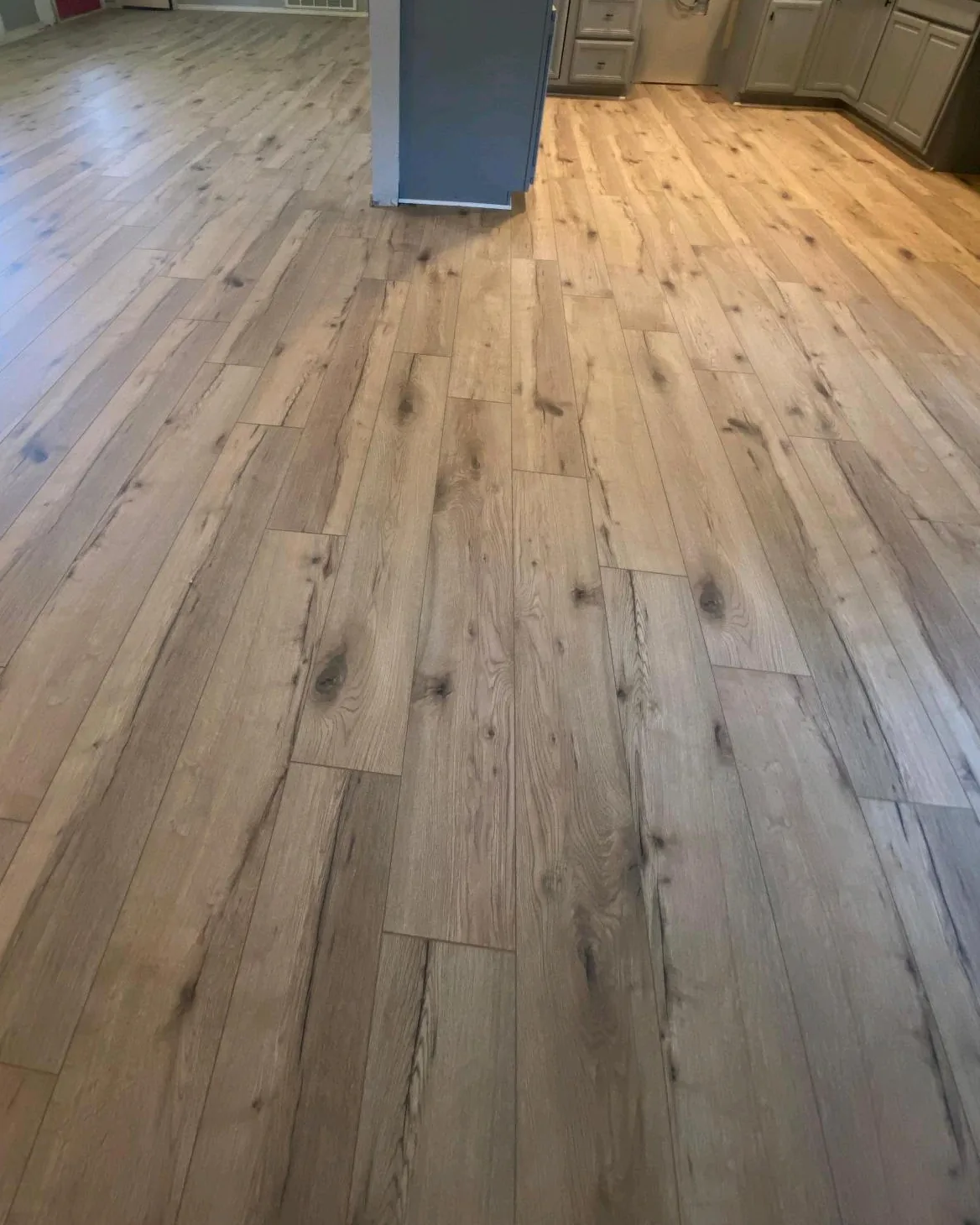Light oak flooring in an open-plan living room and kitchen, installed by Carpet Depot
